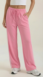 Women's pink wide-leg track pants with elastic drawstring waistband and side stripes.