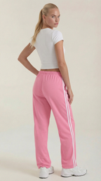 Women's pink wide-leg track pants with drawstring elastic waist and white side stripes.