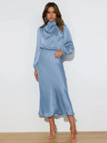 Light blue satin cowl neck midi dress with long sleeves, draped neckline