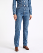 Blue denim jumpsuit with belted waist and straight-leg pants, front view