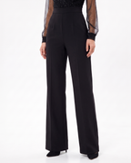 Black wide-leg jumpsuit with tailored waist and sheer dotted cuffs