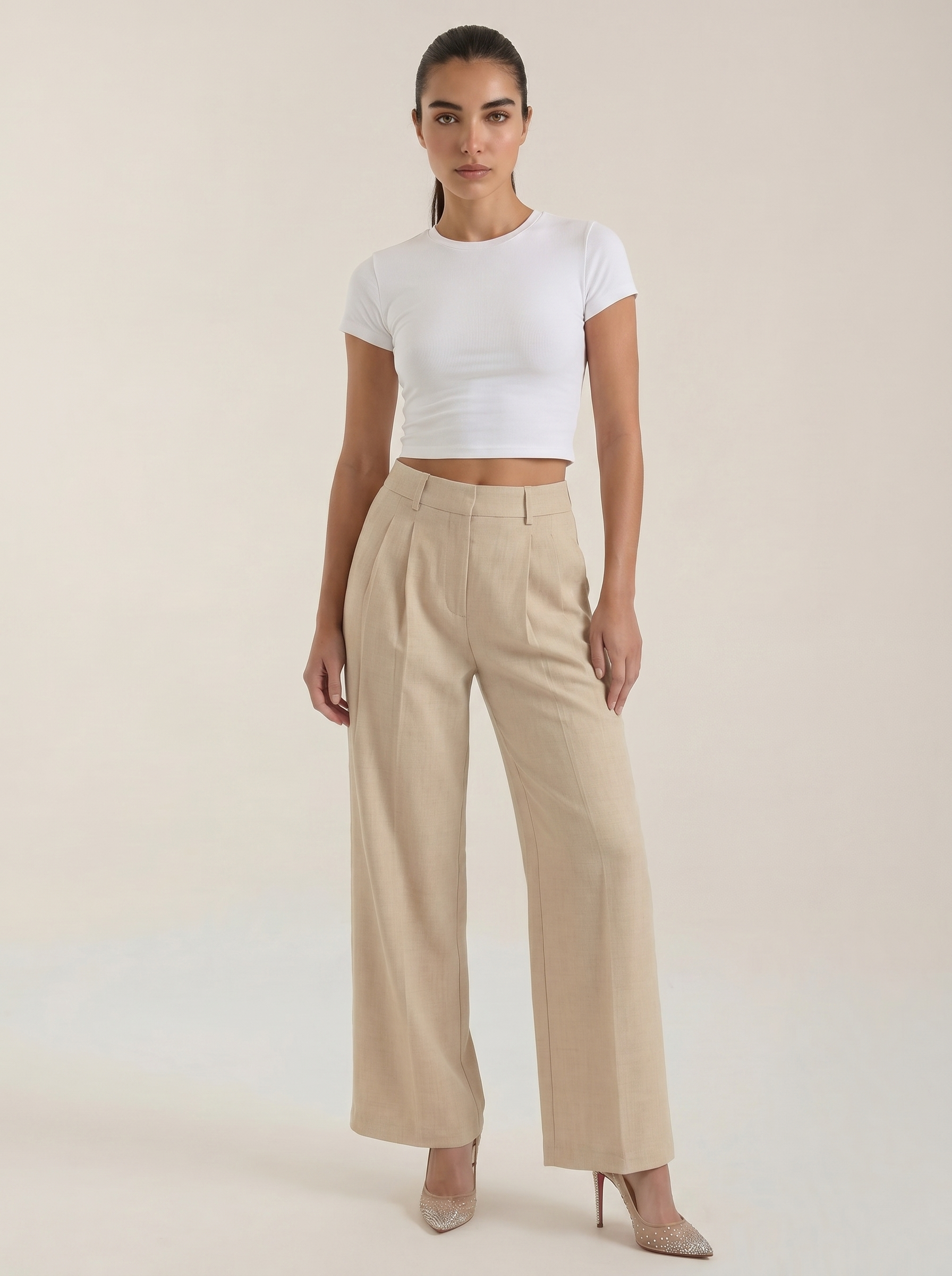 Women’s high-rise pleated wide-leg pants in beige, full length, zip front.