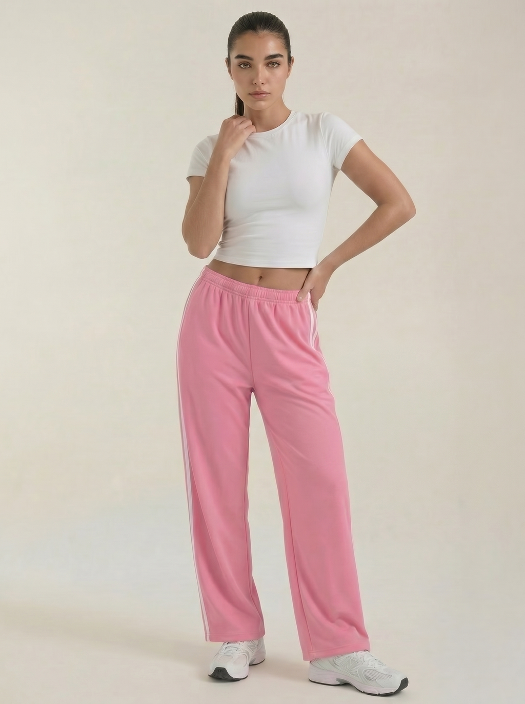 Women's pink wide-leg track pants with drawstring elastic waist and side stripes.