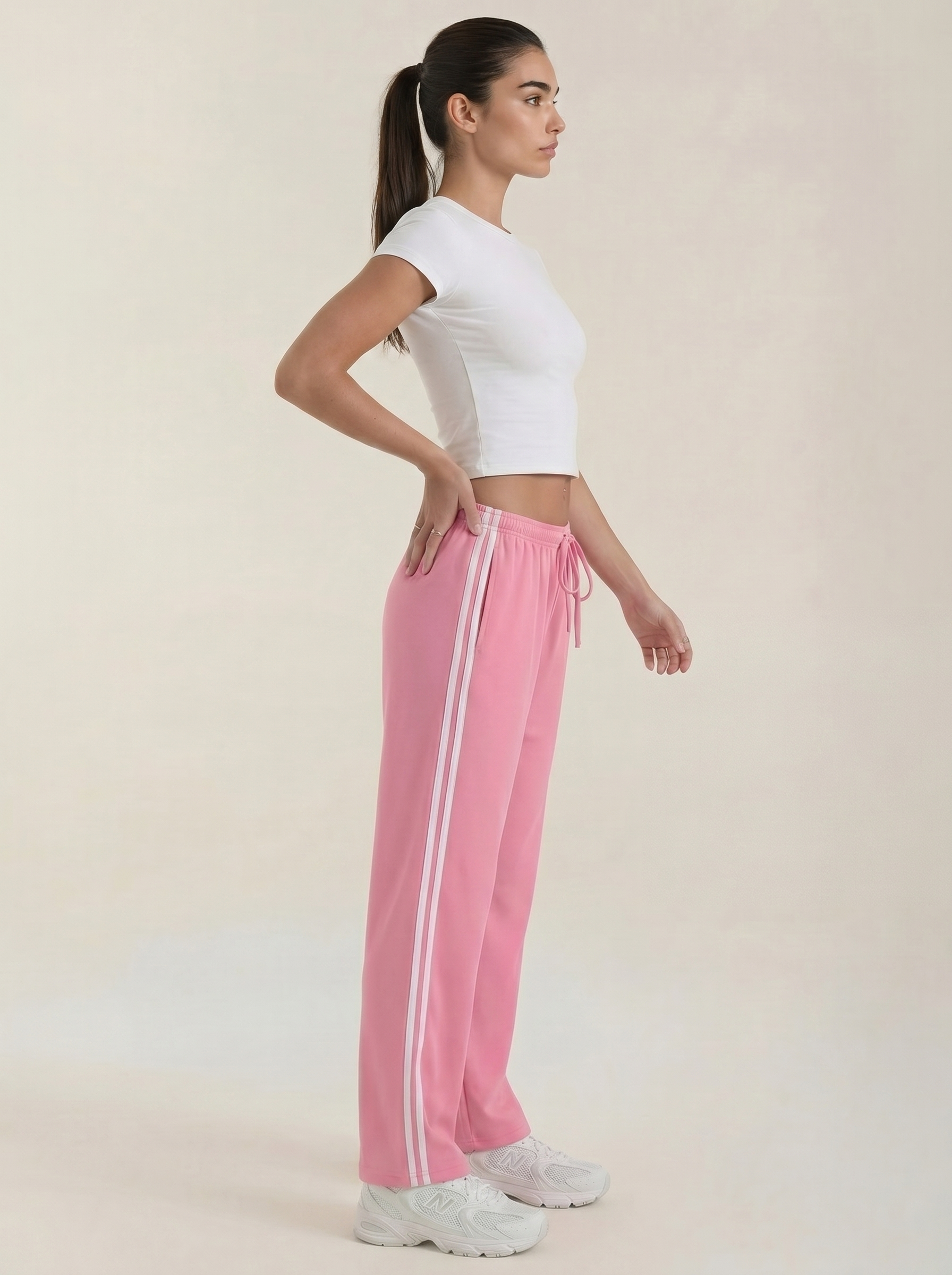 Women's pink wide-leg track pants with drawstring elastic waist and vertical side stripes.
