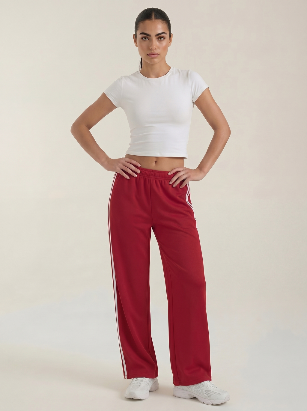 Women's red wide-leg track pants with drawstring elastic waist and white side stripes.