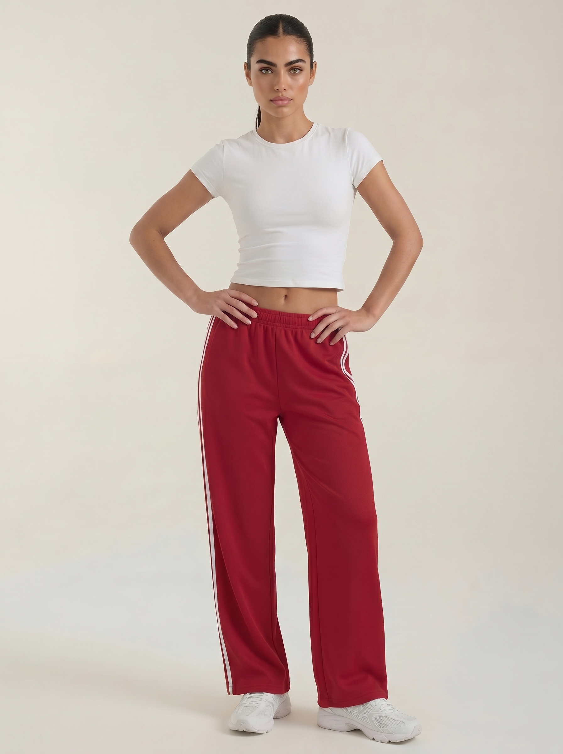Women's red wide-leg track pants with drawstring elastic waist and white side stripes.