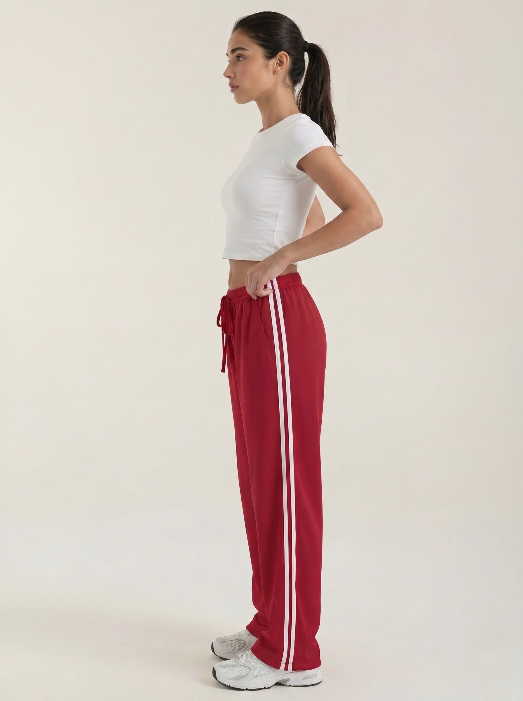 Women's red wide-leg track pants with drawstring elastic waist and white side stripe.