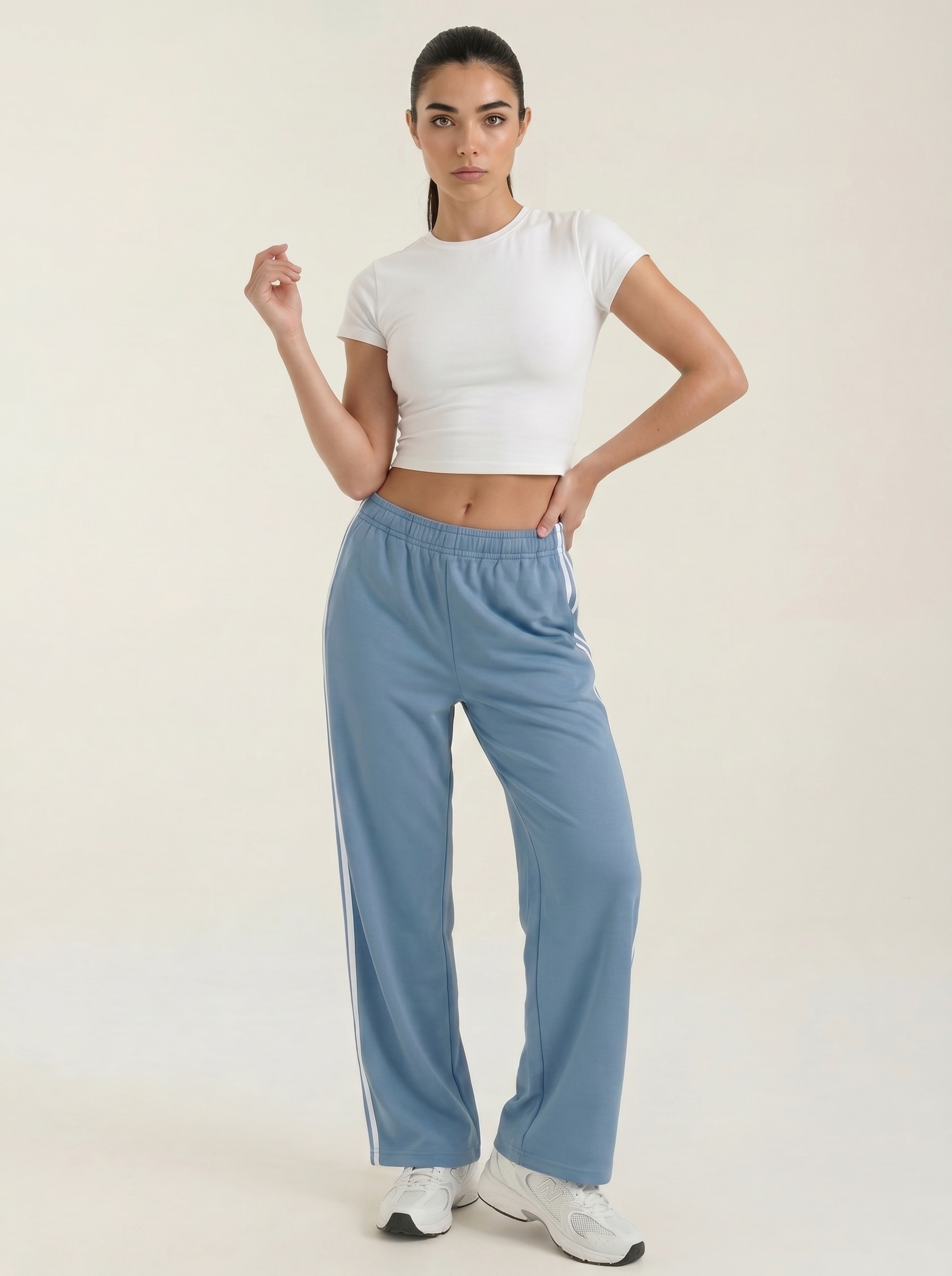 Women's blue wide-leg track pants with drawstring elastic waist and side stripe detail.