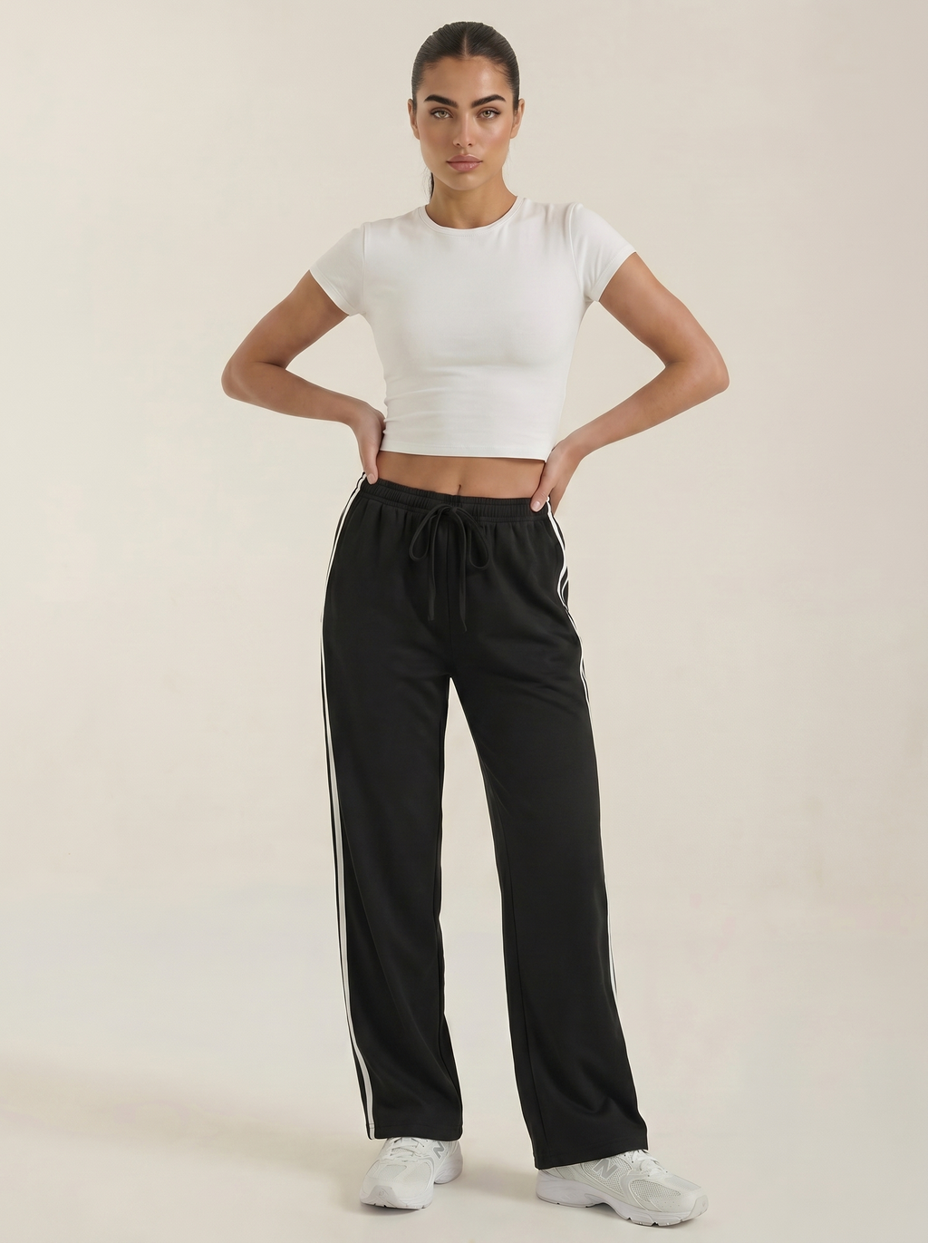 Women's black wide-leg track pants with drawstring elastic waist and side stripe detail.