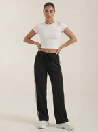 Women's black wide-leg track pants with drawstring elastic waist and side stripe detail.